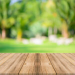 Wooden board empty table in front of blurred background. Perspective grey wood over blur trees in forest - can be used for display or montage your products. spring season. vintage filtered image.